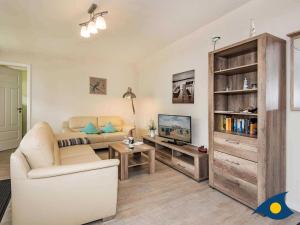 a living room with a couch and a tv at Villa Livia Whg 13 in Ahlbeck
