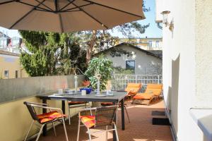 eine Terrasse mit Tisch und Stühlen und einem Sonnenschirm in der Unterkunft Villa Malve Wohnung 05 in Bansin