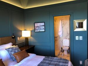 1 dormitorio con paredes azules, 1 cama y aseo en Rambla Montevideo, en Montevideo