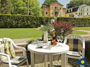 NeuhofにあるVilla Sonnenschein Whg 03の白いテーブル(椅子2脚付)とワイン1本
