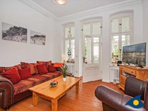 una sala de estar con un sofá y una mesa en Villa Waldblick Whg 05, en Bansin