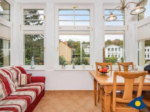 sala de estar con sofá, mesa y ventanas en Villa Waldblick Whg 05, en Bansin 11 fotos más