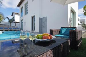 een tafel met een fruitschaal en twee glazen wijn bij Villa Serena in Protaras