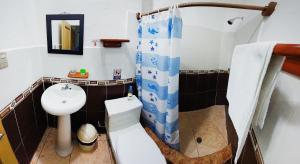 a bathroom with a sink and a toilet and a shower at Hotel Crossman in Puerto Ayora