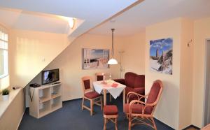 a living room with a table and chairs at Cafe Störmhuus in Neuharlingersiel