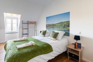 sypialnia z dużym łóżkiem i dużym obrazem na ścianie w obiekcie Gîte le Couderc w mieście Gabriac