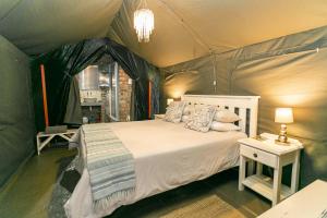 a bedroom with a bed in a tent at Schoemanshoek Glamping in Oudtshoorn