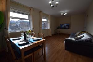 een woonkamer met een tafel en een bank bij Prime Location Apartment in Belfast