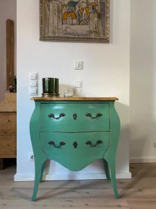 a green dresser in a room with a picture on the wall at Hofquartier in Rostock