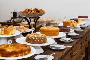 un tavolo con molti tipi diversi di torte e pasticcini di Hotel Serra Vista a Tiradentes