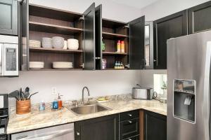 a kitchen with black cabinets and a stainless steel refrigerator at Cozy Pittsburgh Home with King Beds - short drive to all in Pittsburgh