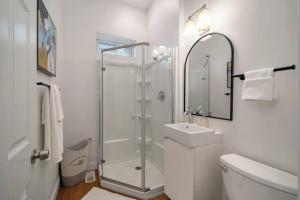 a white bathroom with a shower and a sink at Cozy Pittsburgh Home with King Beds - short drive to all in Pittsburgh