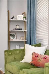 a green couch in a living room with a window at Cozy Pittsburgh Home with King Beds - short drive to all in Pittsburgh