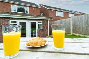 two glasses of orange juice and croissants on a table at Dorchester House in Coventry
