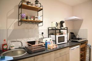 um balcão de cozinha com um lavatório e um micro-ondas em 13 Matheson Place em Portree