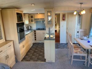 uma cozinha com uma mesa e uma sala de jantar em Lovely Static Holiday Caravan near Whithorn em Whithorn