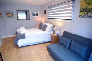 a bedroom with a bed and a blue couch at 13 Matheson Place in Portree