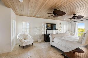 a bedroom with a bed and a ceiling fan at Villa of the Setting Sun in Pirates Cove