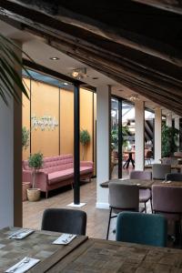 a restaurant with a pink couch and tables and chairs at Petit Palace Preciados in Madrid