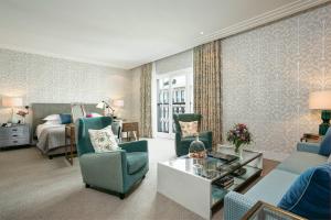 a living room with a couch and chairs and a bed at Rocco Forte The Charles Hotel in Munich