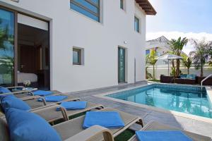 een villa met een zwembad en ligstoelen bij Villa Serena in Protaras