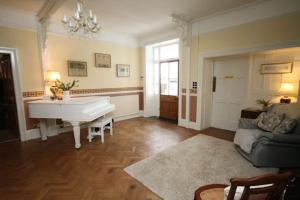 uma sala de estar com um piano e um sofá em Leahurst Bed and Breakfast em Tywyn