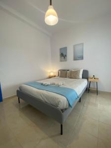a bedroom with a large bed with a blue blanket at Amiais River Beach House in Amiães de Baixo