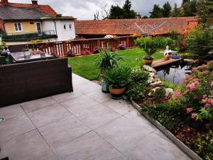 einen Garten mit einer Terrasse und einem Teich mit Pflanzen in der Unterkunft ​Gästehaus Frans-Jozef in Mönichkirchen