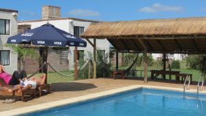 拉帕洛马La Paloma del Mar的躺在游泳池旁的吊床上的人