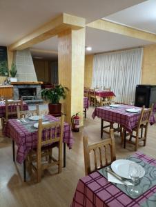 a restaurant with purple tables and chairs and a fireplace at O novo alto do couso in Ourense