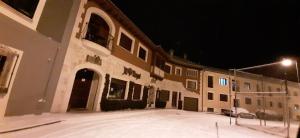 a large building at night with snow on the ground at APARTAMENTOS TURÍSTICOS Y SUITES in Madrona