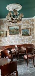 a dining room with benches and a stone wall at APARTAMENTOS TURÍSTICOS Y SUITES in Madrona