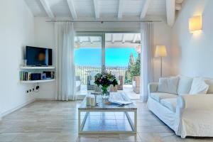 sala de estar con sofá blanco y mesa de cristal en Villa Gelsomino a soli 500 mt dal mare con piscina privata e vista mare, en Castiadas