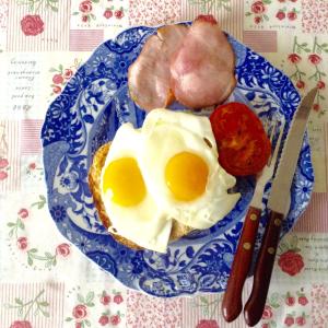 a plate with eggs and meat on a table at Homestay Arrabella in Availles-Limouzine