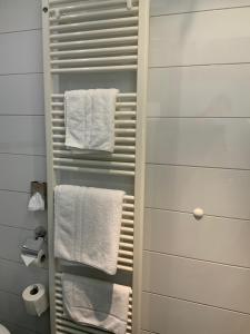 ein Badezimmer mit weißen Handtüchern auf einem Handtuchhalter in der Unterkunft RheinHotel ARTE in Remagen