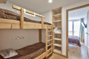 a bedroom with two bunk beds and a mirror at Grand appartement 12 personnes au pied des pistes in Les Deux Alpes