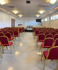 une pièce vide avec des chaises rouges dans une pièce dans l'établissement Hotel Delphin-Nouadhibou, à Nouadhibou