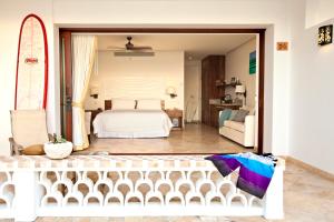 a bedroom with a bed and a surfboard at Cabo Surf Hotel in San José del Cabo +30 photos