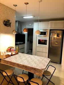 cocina con encimera y nevera en Apartamento em Capão da Canoa beira mar, en Capão da Canoa