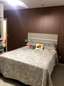 1 dormitorio con 1 cama grande y edredón blanco en Apartamento em Capão da Canoa beira mar, en Capão da Canoa