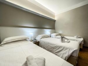 モンティキアーリにあるHotel Elefanteのベッド2台と椅子が備わる客室です。