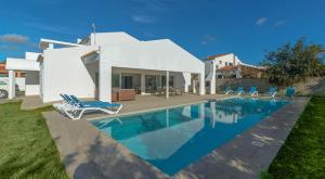 a villa with a swimming pool in front of a house at Villa Son Blanc Grupo Seranova Luxury Hotel in Sa Caleta