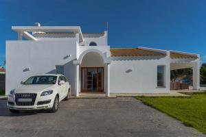 a white car parked in front of a white house at Villa Son Blanc Grupo Seranova Luxury Hotel in Sa Caleta