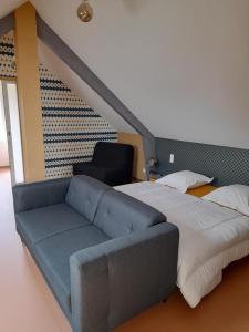 ein Schlafzimmer mit einem Bett und einem blauen Sofa in der Unterkunft CH MALAVETULA in Chastel-Nouvel
