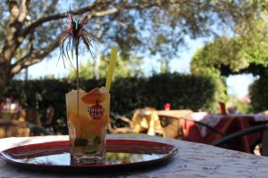 a drink sitting on a plate on a table at Hotel Lu Pitrali in San Teodoro