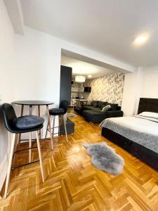 a bedroom with a bed and a table and chairs at Apartman city center 3-šetalište in Prijedor
