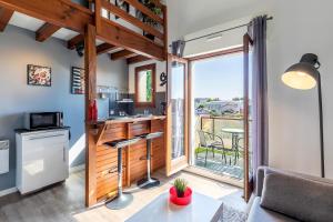 a kitchen and living room with a view of a balcony at DUPLEX DESIGN TERRASSE - Parking in Mont-de-Marsan