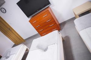 a room with two chairs and a dresser with a tv at Hostel 55 - darmowy parking in Wrocław
