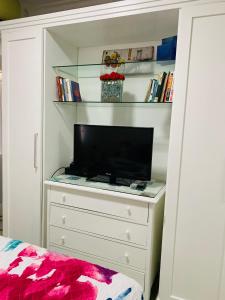 a bedroom with a dresser with a tv on it at Studio perto do Cristo carnaval circuito ondina in Salvador