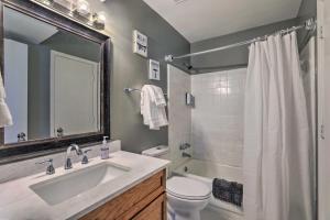a bathroom with a sink and a toilet and a mirror at Fire Pit, Gazebo and Hot Tub North Charleston Home! in Charleston +21 photos